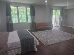 A spacious room with a large window, a sofa, and a fluffy rug. - Comfortable private retreat in the Ashburn, VA (Ashburn)