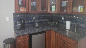 A kitchen with wooden cabinets, a granite countertop, a microwave, a toaster, and a sink. - Comfortable private retreat in the Ashburn, VA (Ashburn)