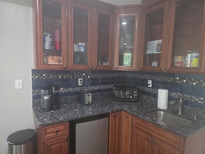 A kitchen with wooden cabinets, a granite countertop, a microwave, a toaster, and a sink. - Comfortable private retreat in the Ashburn, VA (Ashburn)