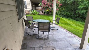 An outdoor patio with a stone floor, a round table, and four chairs. - Comfortable private retreat in the Ashburn, VA (Ashburn)