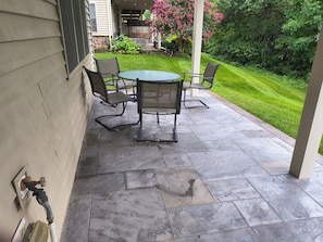 An outdoor patio with a stone floor, a round table, and four chairs. - Comfortable private retreat in the Ashburn, VA (Ashburn)