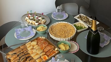 Un tavolo da pranzo con diversi piatti, una bottiglia di champagne e una sedia.