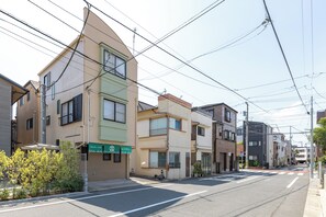 A residential street with multi-story buildings, a clear sky, and visible power lines. - Vrbo Property (江戸川区)