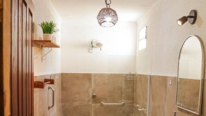A bathroom with a toilet, sink, shower, and a hanging light fixture. - Rancho Alegre c/ Wi-fi, Ar Condicionado e Natureza (Itabaiana)