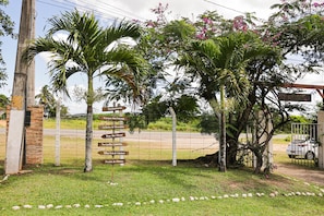 A signpost with multiple directional arrows, a brick wall, and a grassy area with scattered stones.