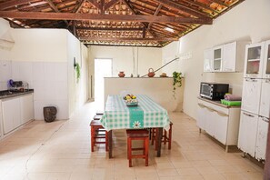 A kitchen with a table set for four, a microwave, and cabinets.