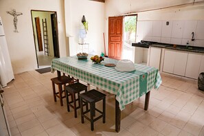 A dining area with a checkered tablecloth, a bowl of fruit, and a water dispenser.