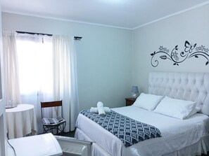 A hotel room with a bed, a chair, a table, and a window with curtains. - HOTEL 3 PONIENTE (Viña del Mar)