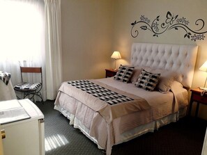 A hotel room with a large bed, two bedside tables with lamps, a chair, and a desk with a lamp. - HOTEL 3 PONIENTE (Viña del Mar)