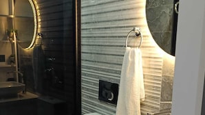 Une salle de bain moderne équipée de toilettes, d’un lavabo et d’un miroir.