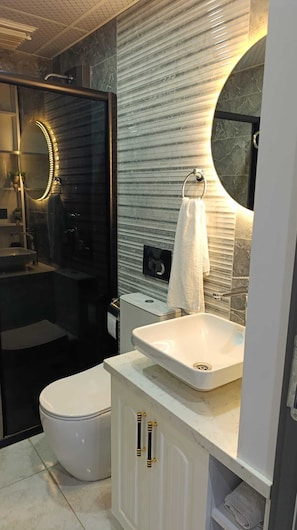 A modern bathroom with a toilet, sink, and mirror. - Stunning 2-Bedroom Villa with Heated Pool & Jacuzzi in Antalya, Kemer (Antalya)