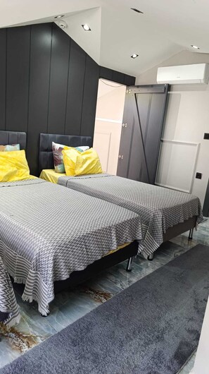 A modern bedroom with two beds, a dark wall, and a grey carpet. - Stunning 2-Bedroom Villa with Heated Pool & Jacuzzi in Antalya, Kemer (Antalya)