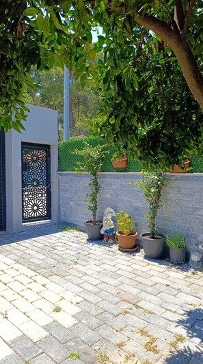 A paved courtyard with potted plants and a decorative gate. - Stunning 2-Bedroom Villa with Heated Pool & Jacuzzi in Antalya, Kemer (Antalya)