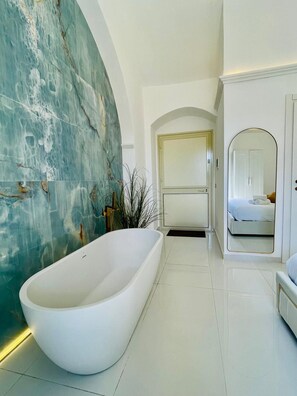Ein modernes Badezimmer mit einer freistehenden Badewanne, einem großen Spiegel und einer separaten Duschkabine.