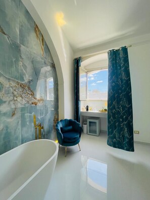 A modern bathroom with a freestanding bathtub, a vanity with a mirror, and a shower area.