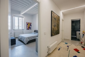 A modern bedroom with a bed, a radiator, a window, and a door leading to a bathroom. - Vrbo Property (Arezzo)