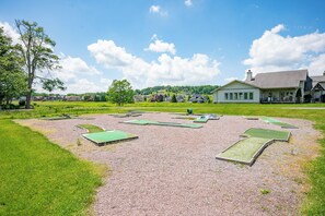 A golf course with multiple green fields and a clubhouse in the background. - New! Luxurious Lake Access Getaway w/ Indoor Pool (Swanton)