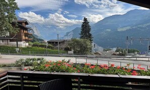 A mountain view with a railway track, a wooden building, and a flower bed. - WENGEN PENTHOUSE • 1 MIN TO TRAIN • 3 MIN TO MÄNNLICHEN GONDOLA (Lauterbrunnen)