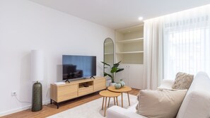 A modern living room with a flat-screen TV, a wooden cabinet, a round coffee table, and a white sofa. - Polacos Residence | 2BR | Apt O by LovelyStay (Vila Nova de Gaia)