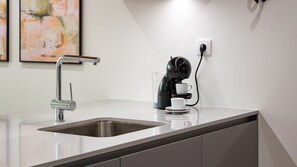 A modern kitchen with a stainless steel sink, a coffee machine, and a power outlet on the countertop. - Polacos Residence | 1BR | Apt B by LovelyStay (Vila Nova de Gaia)