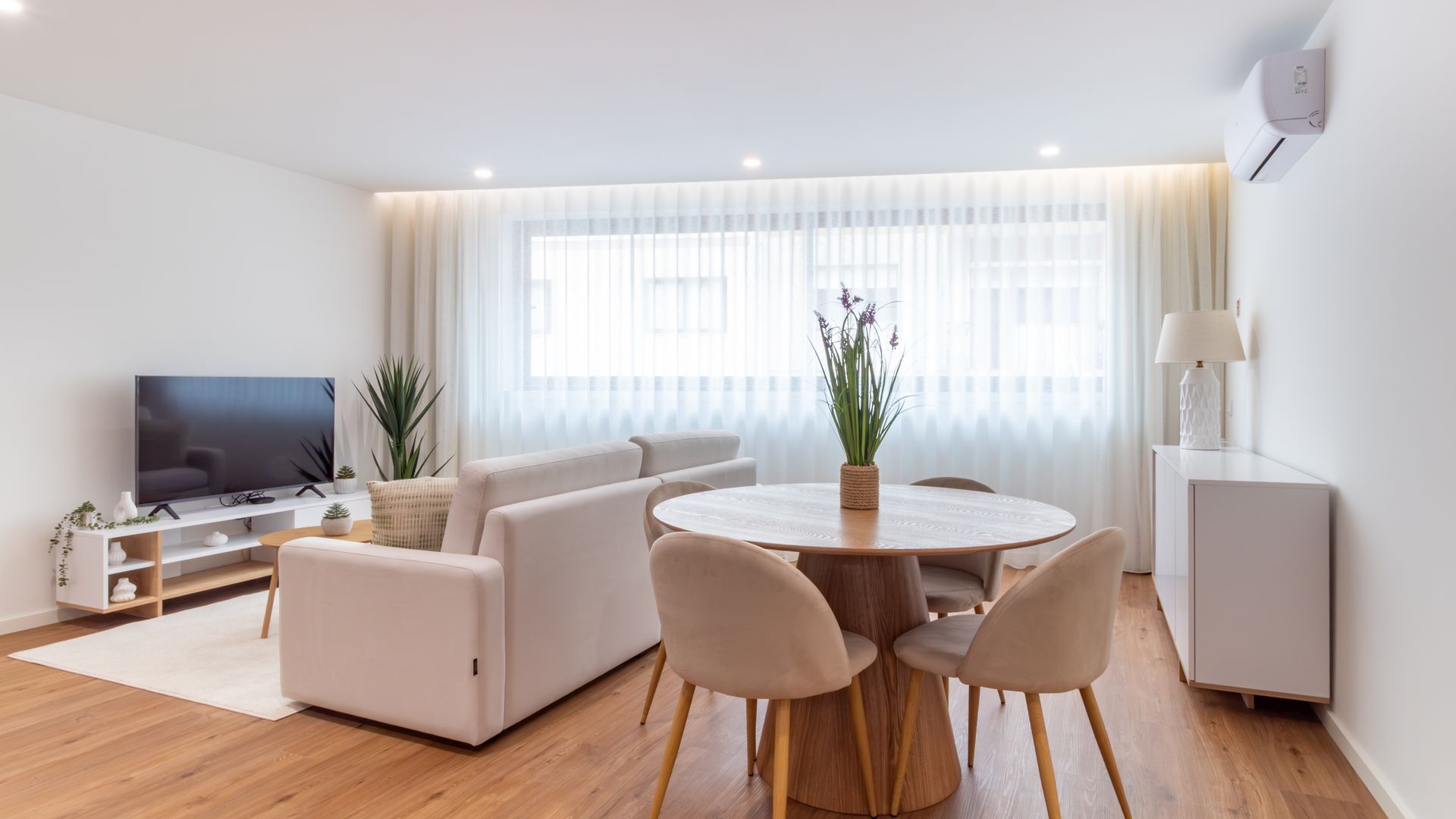 Una sala de estar moderna con un sofá, una mesa de centro y un televisor.