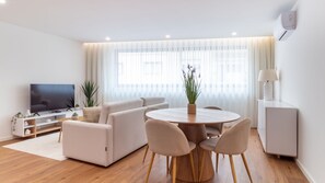 Una sala de estar moderna con un sofá, una mesa de centro y un televisor.