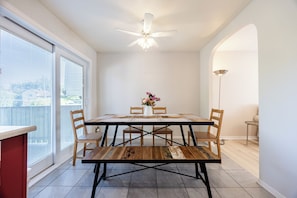 A dining area with a table, chairs, a ceiling fan, and a view through a window. - Spacious 4BR House|15 Min to DT|DIX30|3 Parking| Central AC (Brossard)