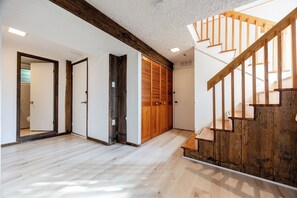 Ein geräumiges Zimmer mit einer Holztreppe, weißen Wänden und einem Holzboden.