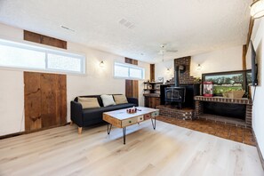 A living room with a sofa, coffee table, fireplace, and a television. - Spacious 4BR House|15 Min to DT|DIX30|3 Parking| Central AC (Brossard)