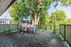A wooden deck with a table and chairs, surrounded by trees and a fence. - Spacious 4BR House|15 Min to DT|DIX30|3 Parking| Central AC (Brossard)