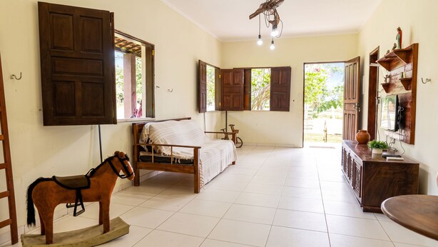 A room with a bed, a wooden rocking horse, a desk, and a television. - Rancho Alegre c Wi-fi Ar Condicionado e Natureza (Itabaiana)