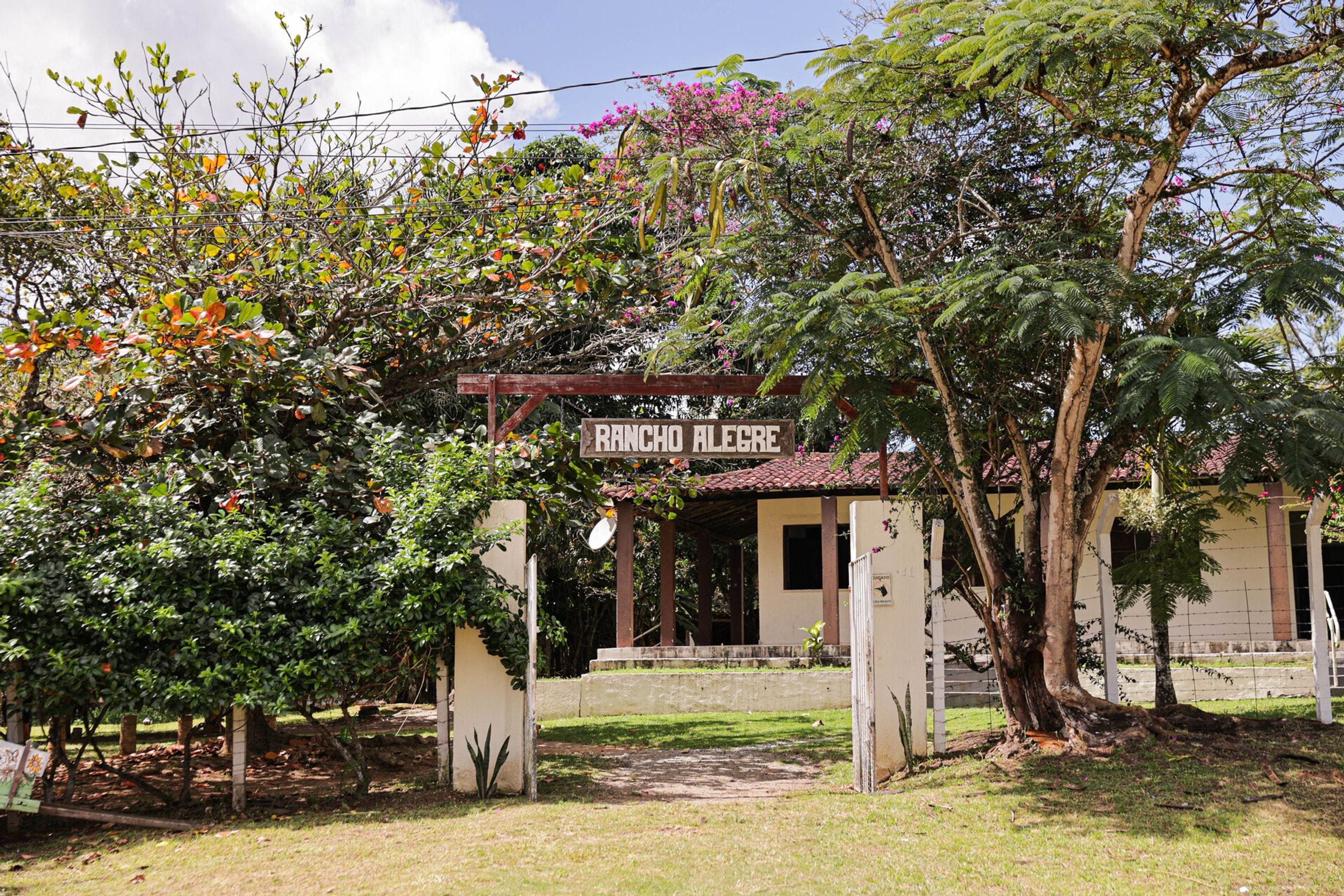 Um edifício com uma placa que diz 'RANCHO ALEGRE' e uma entrada coberta.