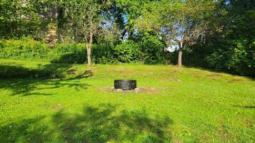 A grassy outdoor area with trees and a black object on the ground.