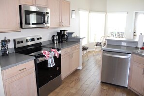 A modern kitchen with stainless steel appliances, wooden cabinets, and a dishwasher. - RC327- Family Retreat: 5BR with Pool & Games Room (DAVENPORT)