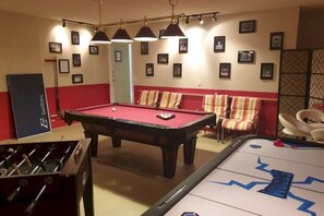 A room with a pool table, foosball table, and a shuffleboard table. - RC327- Family Retreat: 5BR with Pool & Games Room (DAVENPORT)