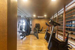 A gym with exercise equipment, a treadmill, and a wall-mounted rack. - Studio in Condo. w/ Pool & City View Bem1405 (São Paulo)