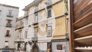 A multi-story building with a sign for 'Pizzeria Oliva' on the ground floor.