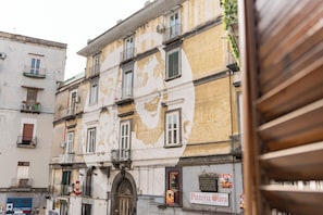 Um edifício de vários andares com uma placa da 'Pizzeria Oliva' no andar térreo.