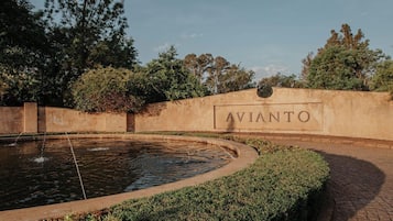 A landscaped area with a circular water feature and a wall with the word 'AVIANTO' on it.