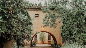 An arched entrance with a potted plant and a wall-mounted light fixture. - Avianto Pty Ltd (Muldersdrift)