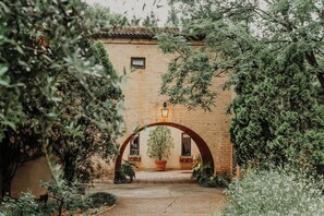 An arched entrance with a potted plant and a wall-mounted light fixture. - Avianto Pty Ltd (Muldersdrift)