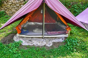 A tent with a raised platform and a sleeping area inside. - Neervan Resort (Banjar)