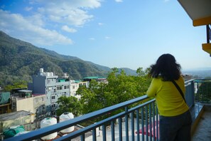 A balcony with a view of a cityscape and mountains. - Bunk Hostel Tapovan (Rishikesh)