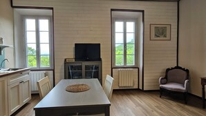 Eine Küche mit Esstisch, Fernseher und einem Stuhl.