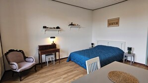 Ein Zimmer mit einem Bett, einem Schreibtisch, einem Stuhl und einer Lampe.