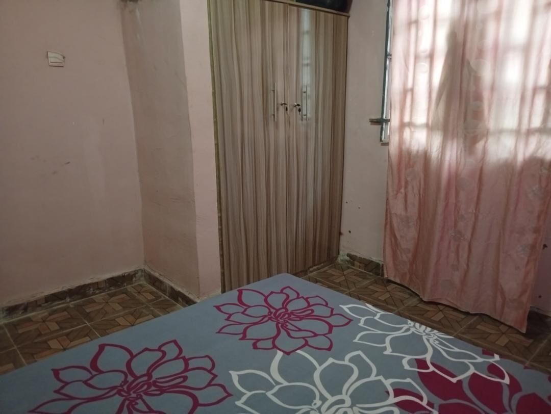 Habitació amb un paviment motllurat, una porta corredissa vertical i una cortina.