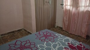 Habitació amb un paviment motllurat, una porta corredissa vertical i una cortina.