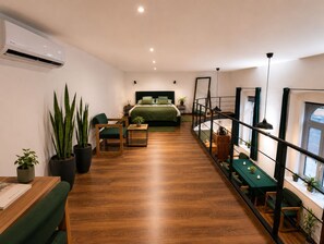 A modern bedroom with a bed, bedside table, and a small seating area with a chair and table. - Cozy loft bedroom apartment in gorgeous Budapest (Budapest)