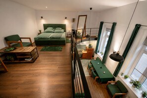 Ein modernes Interieur mit Bett, Sitzgelegenheit, Essbereich und einer Treppe.