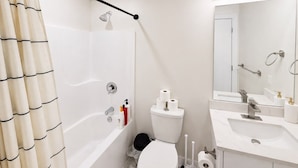 Un baño moderno con ducha, inodoro y lavamanos.